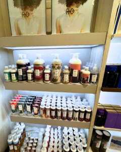 Shelves stocked with various R+Co hair care products, including bottles and tubes of shampoo, conditioner, and styling products. A luxury hair care routine example. - Salon Jaylee | The Villages, FL